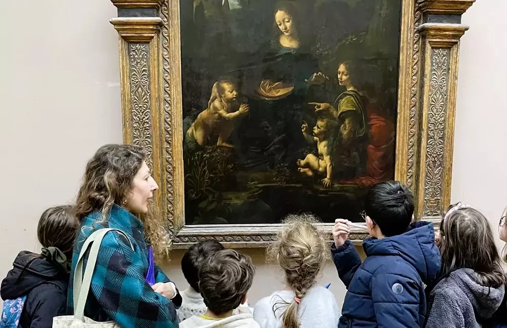 Une guide et des enfants devant La Vierge aux rochers de Léonard de Vinci, au Louvre
