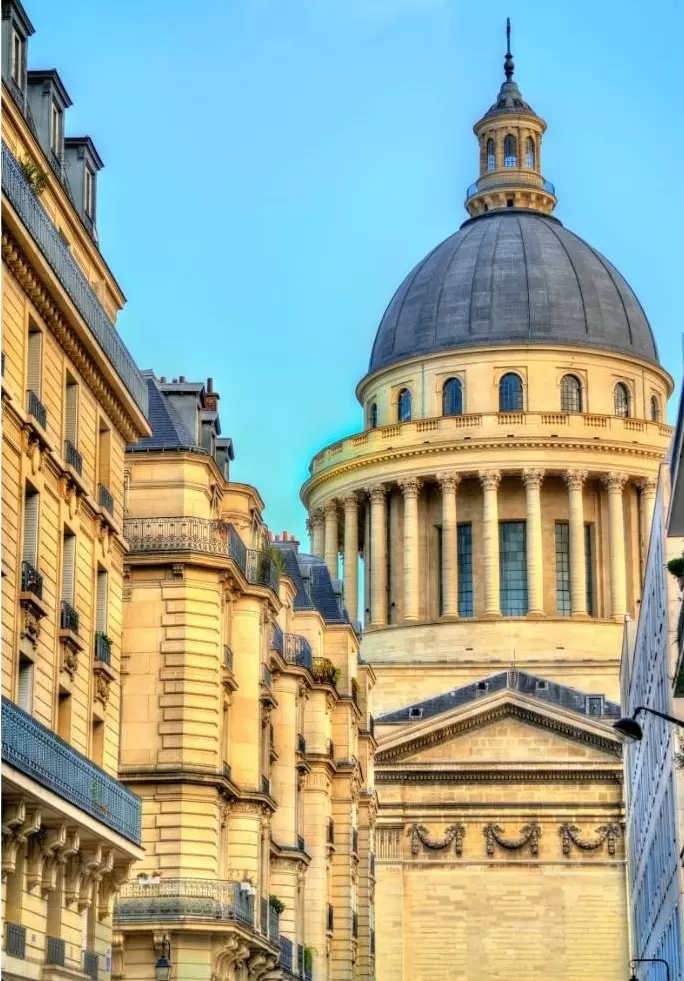 Le dôme du Panthéon vu depuis une rue bordée d'immeubles haussmanniens