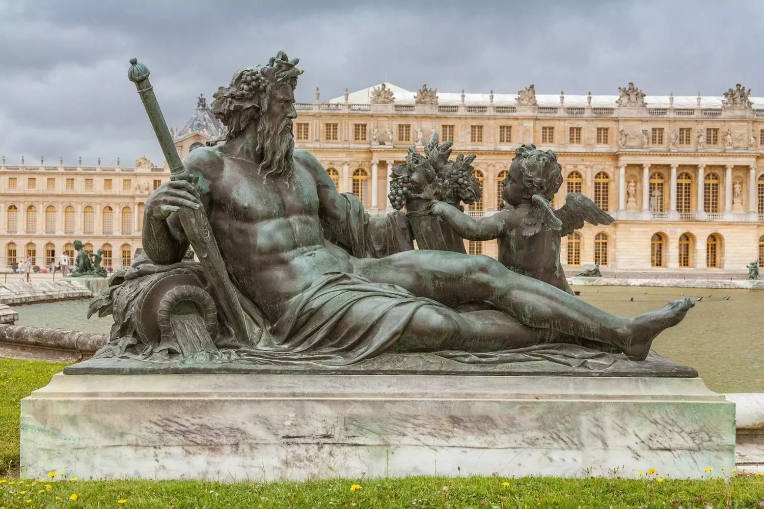 Statue en bronze d'un dieu fleuve allongé, devant la façade du château de Versailles