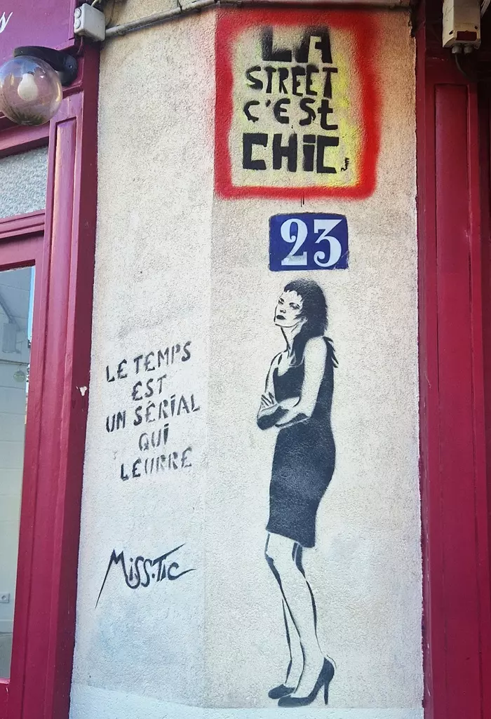 Pochoir de Miss.Tic, femme en robe noire et inscription Le temps est un serial qui leurre
