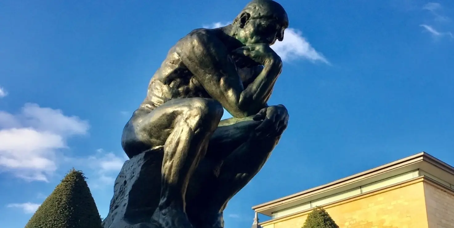 Le Penseur de Rodin en bronze sous un ciel bleu, dans le jardin du musée Rodin
