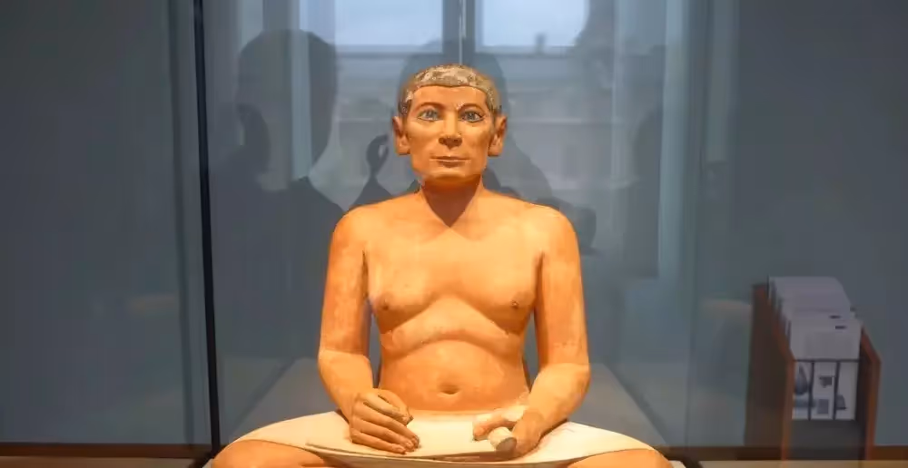 Le Scribe accroupi, statue égyptienne peinte dans sa vitrine au musée du Louvre