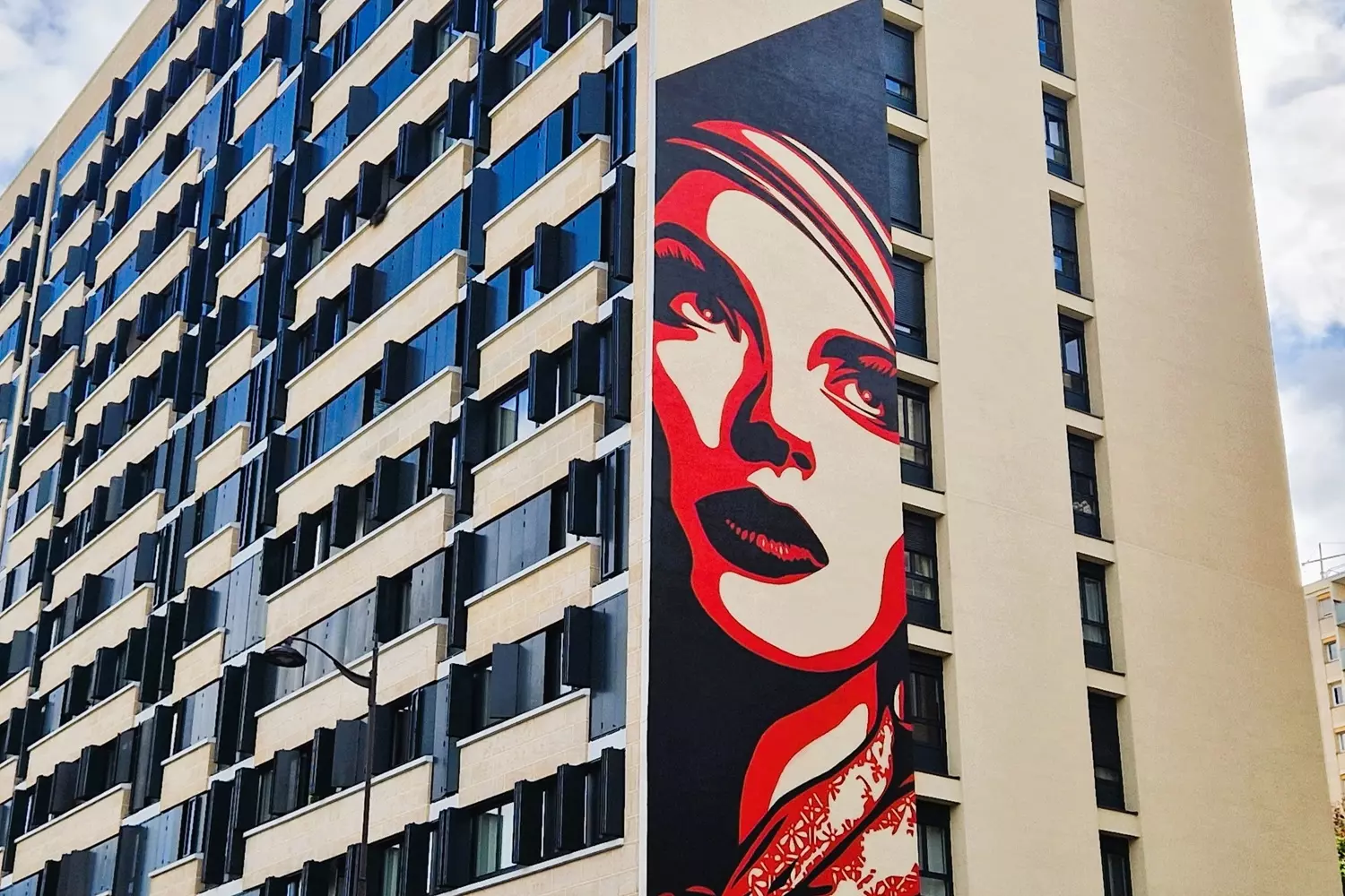 Fresque géante de Shepard Fairey, visage de femme rouge et noir, sur la façade d'un immeuble du 13e