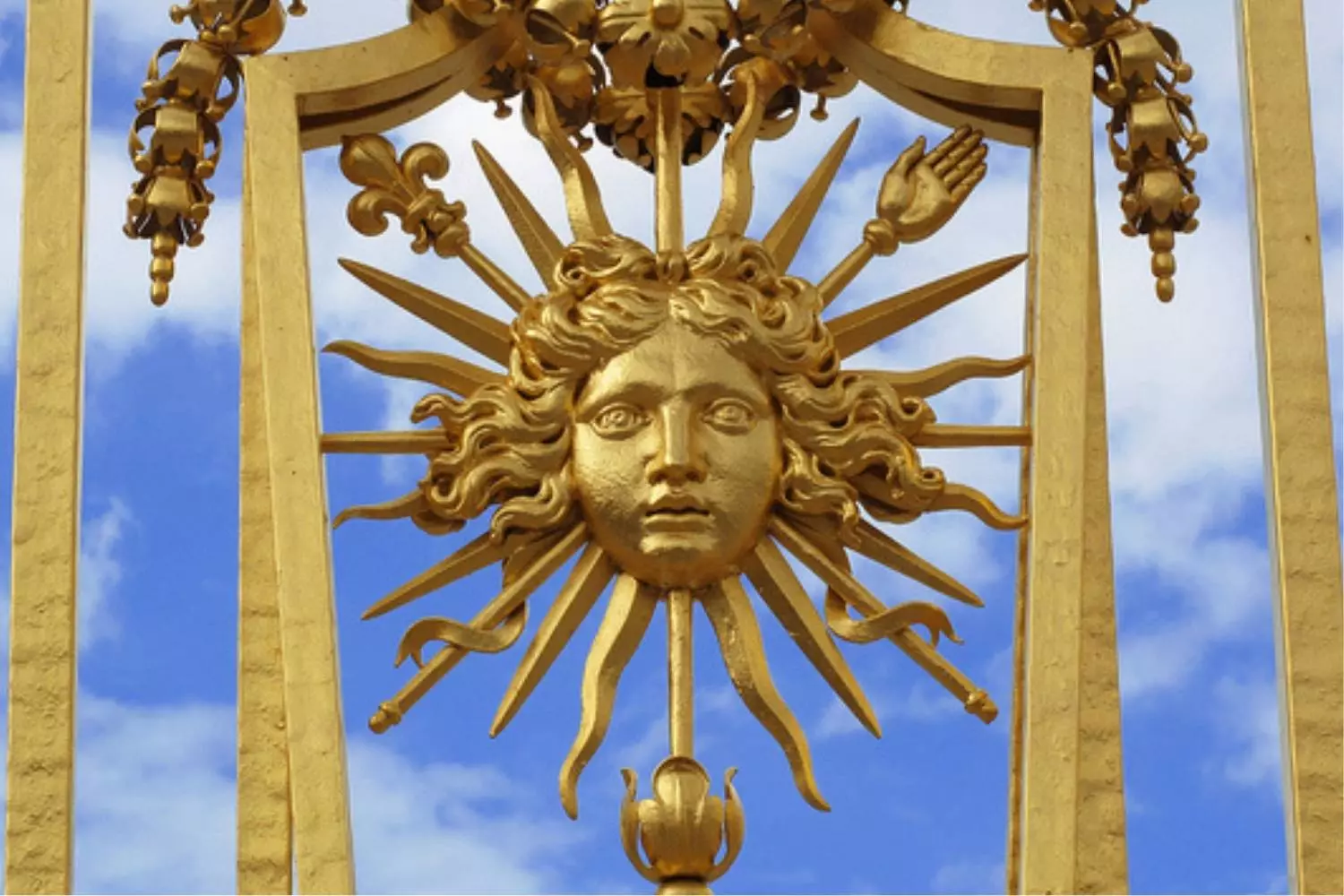 Emblème doré du Roi-Soleil sur la grille du château de Versailles