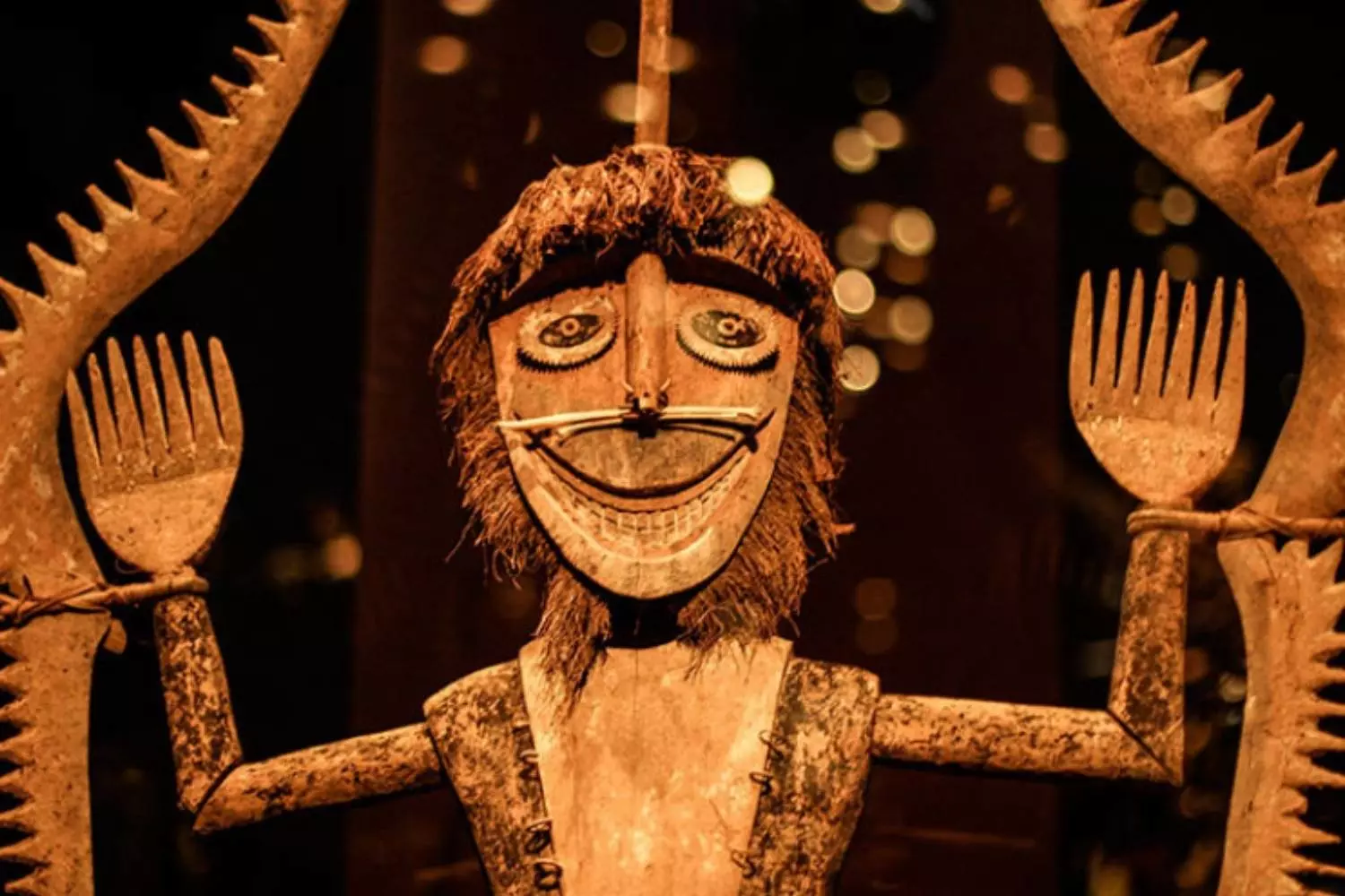 Sculpture en bois au visage souriant et aux bras levés, au musée du quai Branly