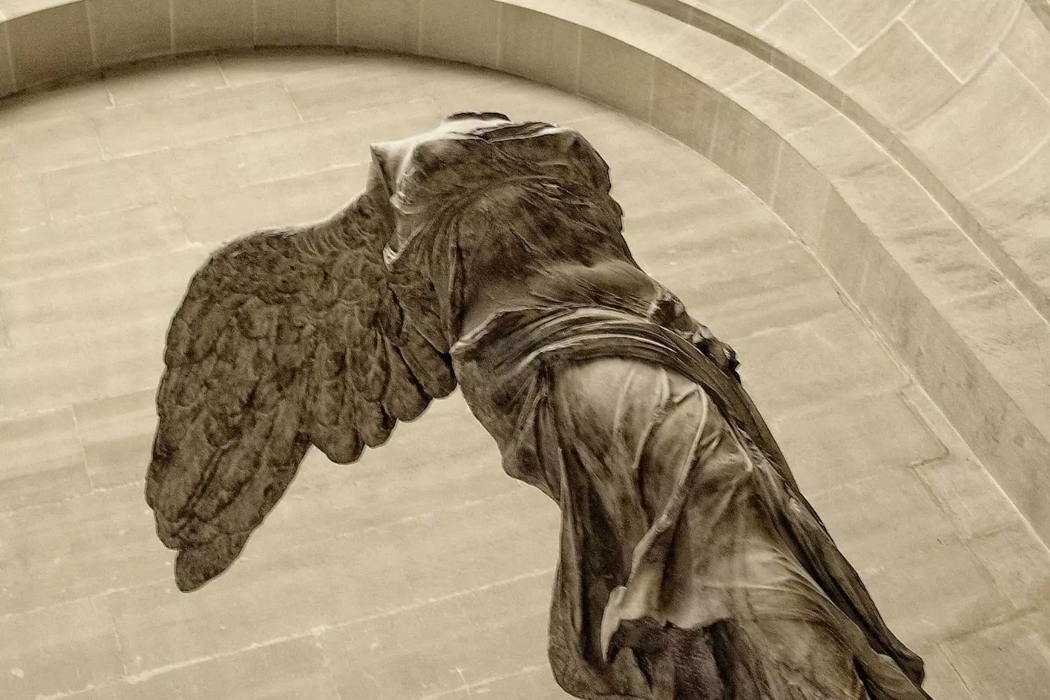 La Victoire de Samothrace vue de côté, ailes déployées, en tons sépia