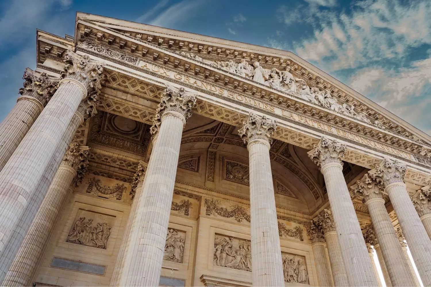 Colonnes et fronton du Panthéon vus en contre-plongée sous un ciel bleu