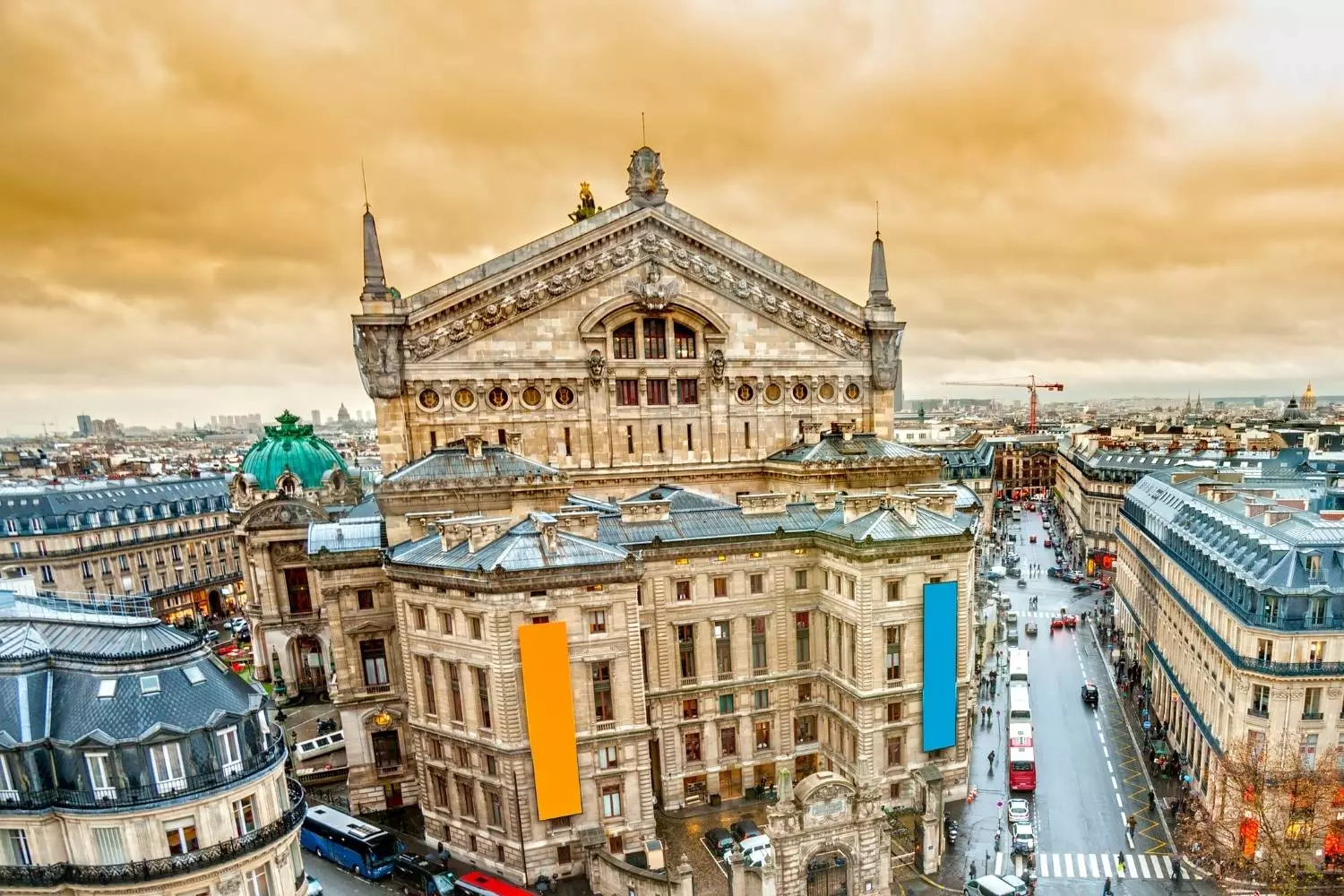 High view of the Palais Garnier and the surrounding Haussmann buildings under a golden sky