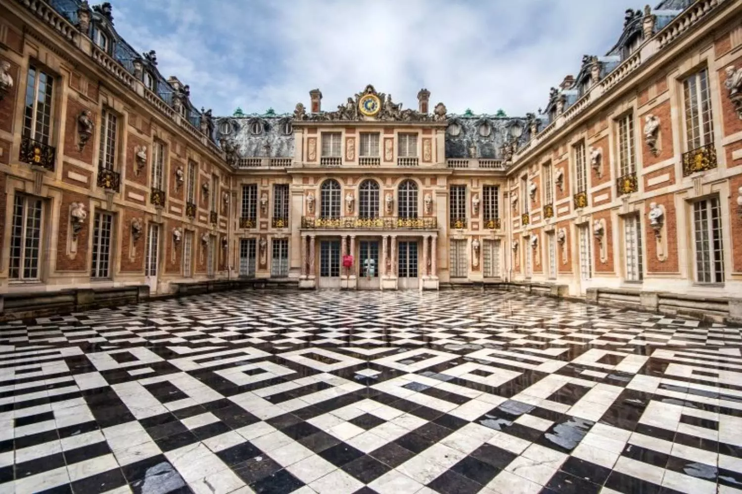 The Marble Courtyard of the Palace of Versailles with its black and white paving