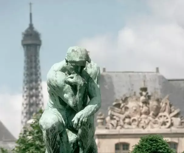 Le Penseur d'Auguste Rodin dans le jardin du musée Rodin, avec la tour Eiffel au loin